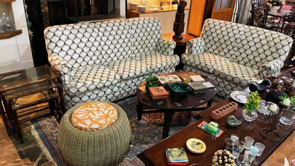 Sala decorada com móveis de segunda mão, sofás vintage e objetos reutilizados, mostrando o conceito de subconsumo e consumo consciente.